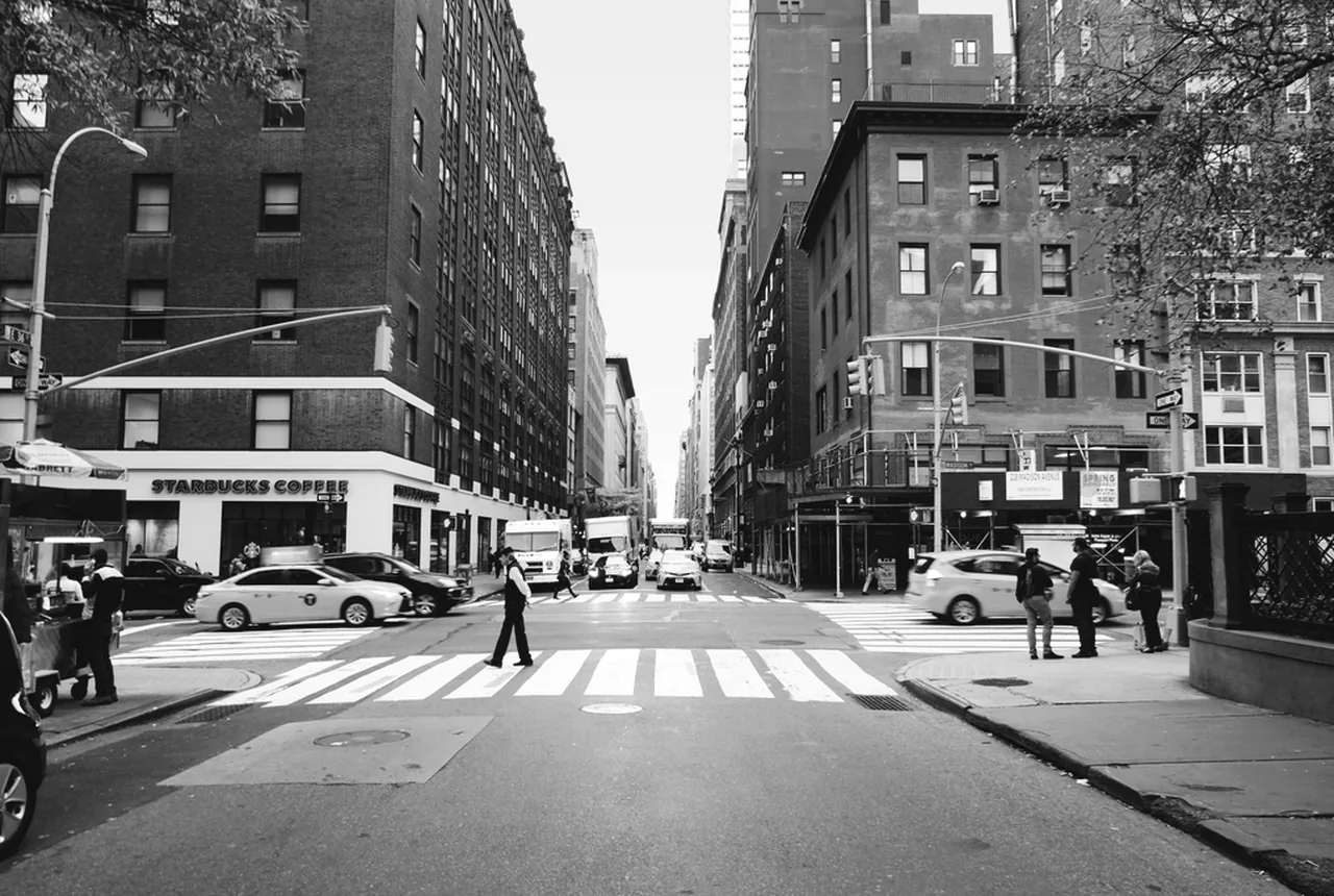 A corner in New York, shopfronts on every side.
